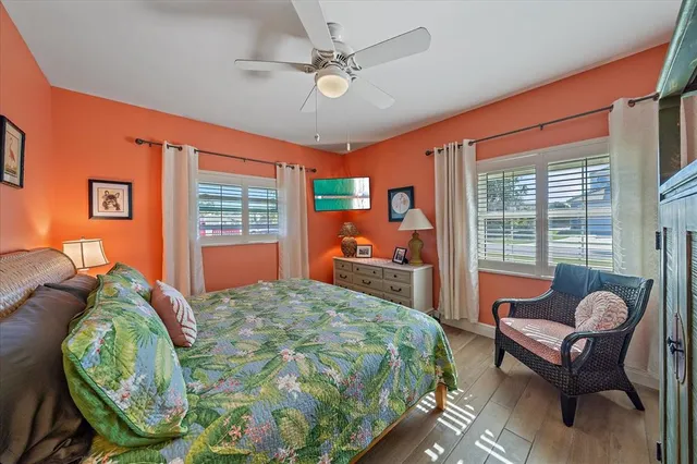 a bedroom with a bed and large windows