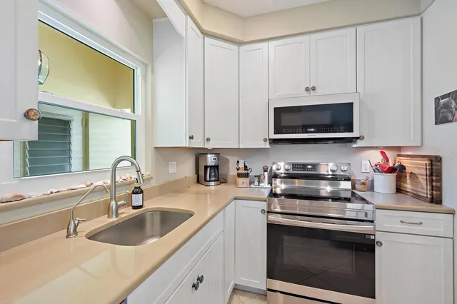 a kitchen with stainless steel appliances granite countertop a sink a stove a microwave and cabinets