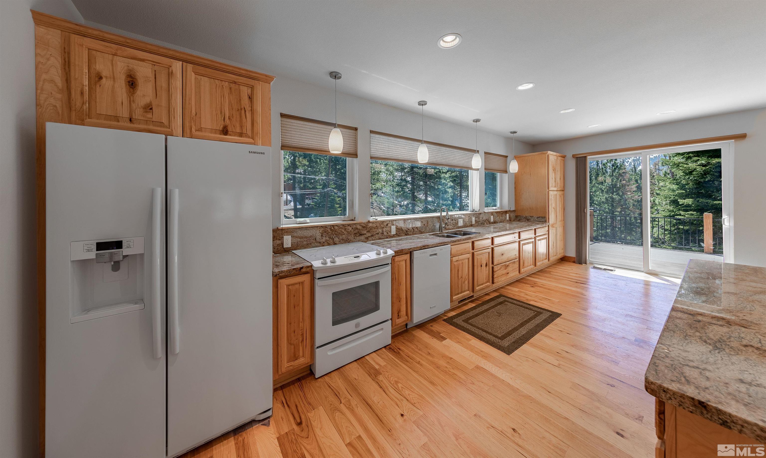 278 Andria Drive Stateline, NV 89449 - Photo 8 of 37 a kitchen with stainless steel appliances granite countertop a refrigerator a stove and a wooden floors
