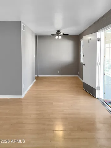 a view of a livingroom with a ceiling fan & entryway