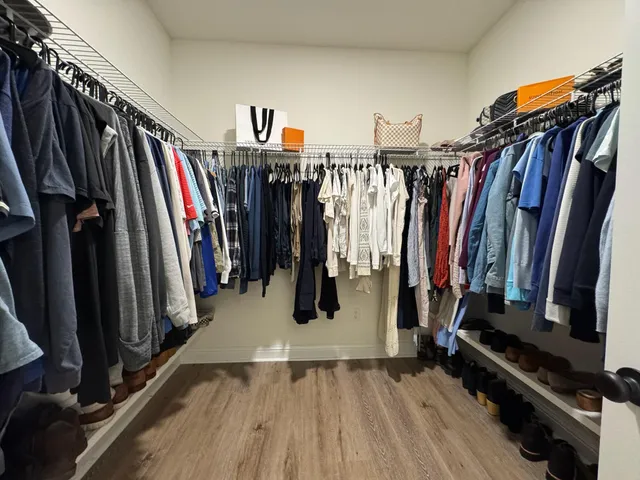 a view of walk in closet with clothes