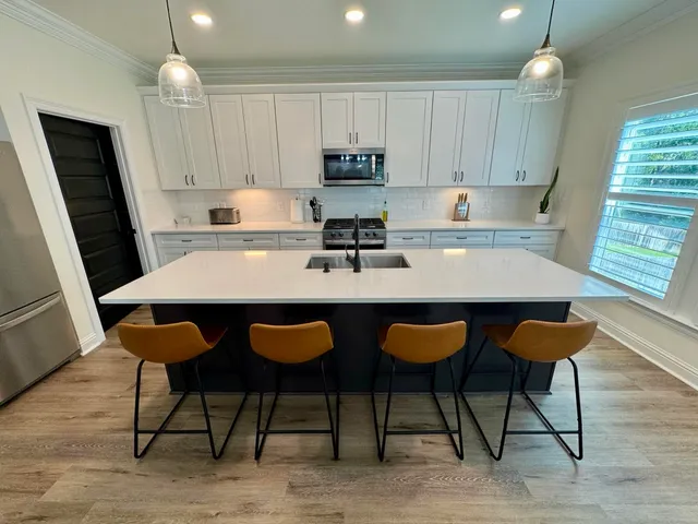 a kitchen with granite countertop a table chairs sink and cabinets