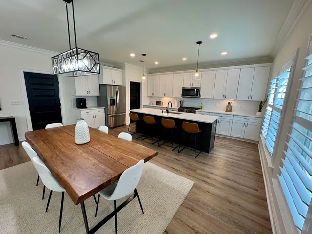 a view of a dining room with furniture a chandelier and wooden floor