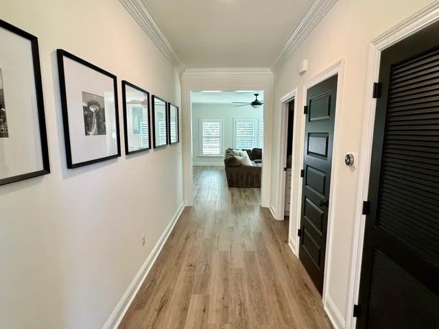 a view of a hallway with wooden floor and staircase