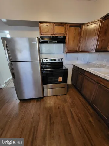 a kitchen with wooden floors and stainless steel appliances