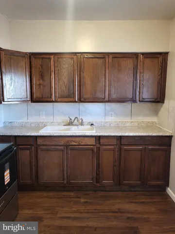 a kitchen with a sink cabinets and wooden floor