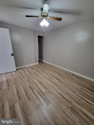 a view of an empty room with a chandelier fan