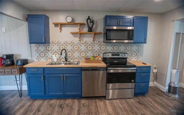 a kitchen with stainless steel appliances wooden cabinets and a stove top oven