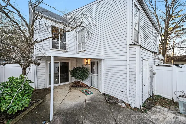 a view of a house with a yard and potted plants
