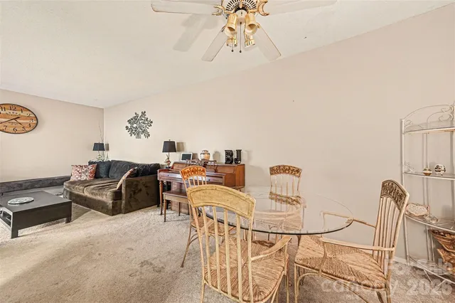 a living room with furniture a rug and white walls