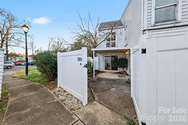 a view of a white house with a small yard and plants