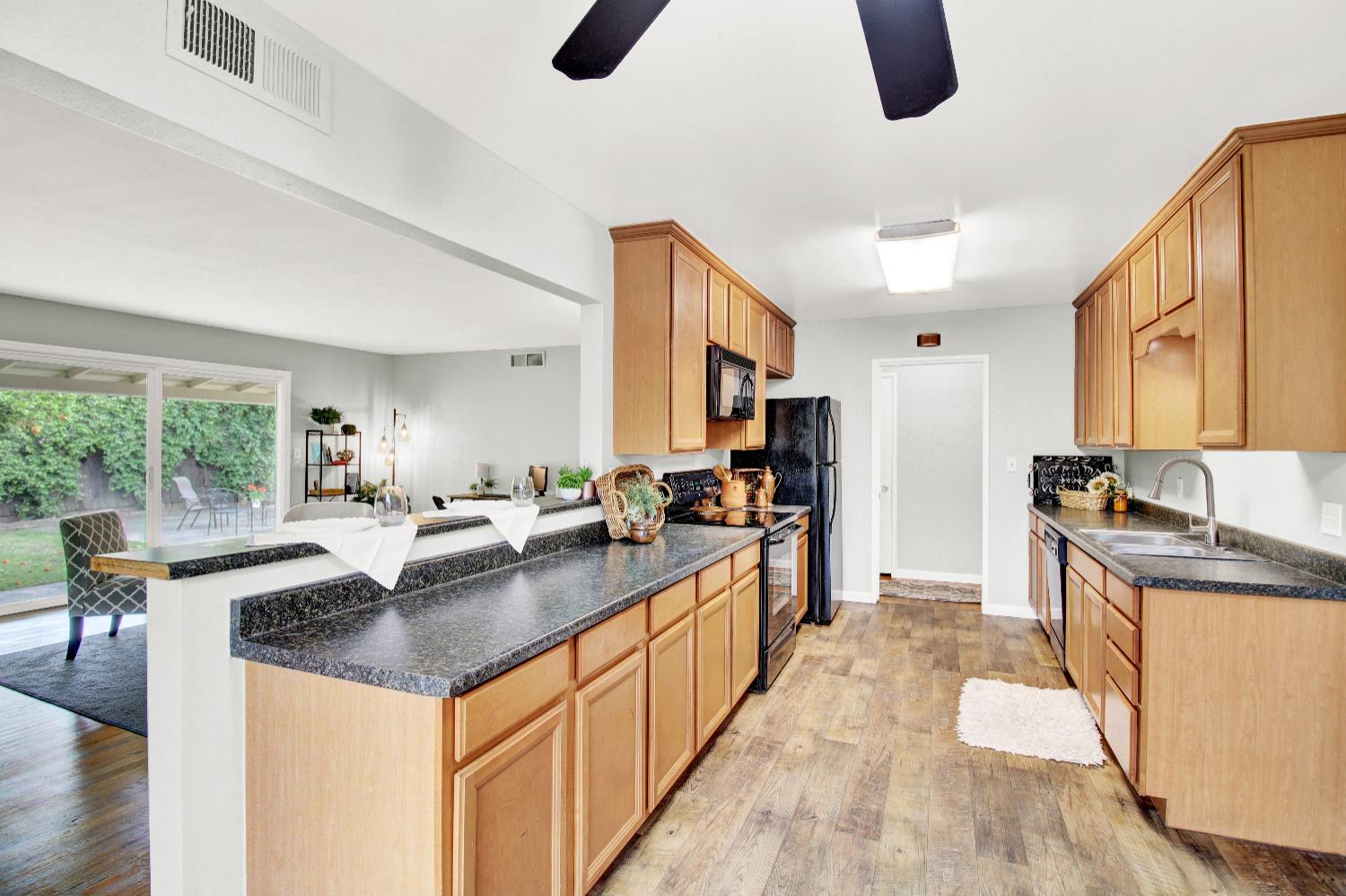 1530 Morene Way Modesto, CA 95355 - Photo 8 of 38 a kitchen with counter top space a sink wooden floor and stainless steel appliances
