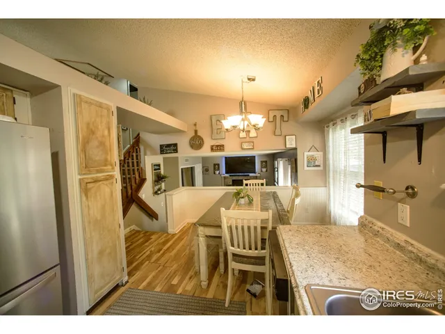 a view of a dining room with furniture a chandelier and wooden floor