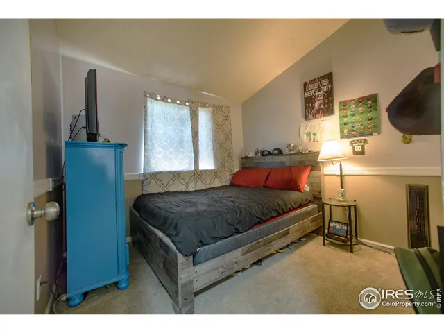 a bedroom with a bed a window and dresser