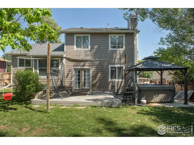 a view of a house with a yard and a large tree