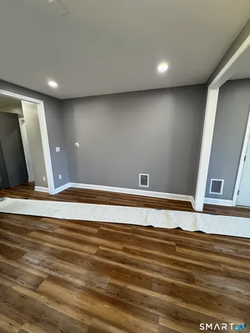 a view of a livingroom with an empty space and wooden floor