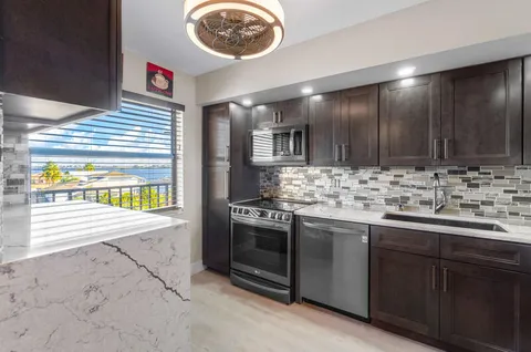 a kitchen with stainless steel appliances granite countertop a sink and a stove