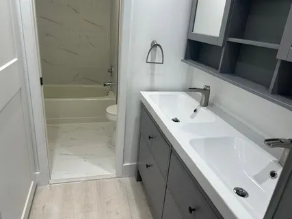a bathroom with a sink a toilet and shower
