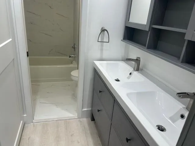 a bathroom with a sink a toilet and shower