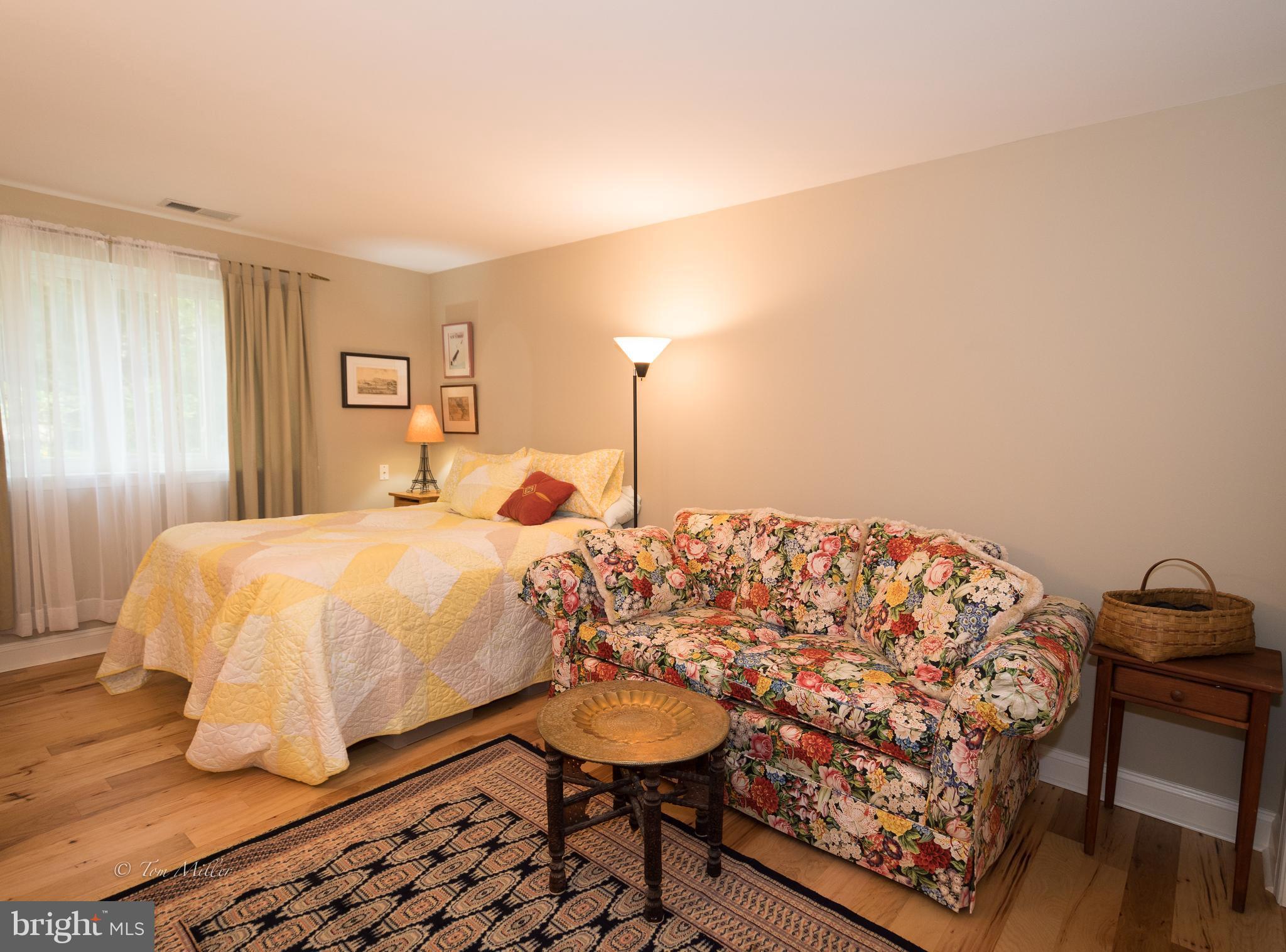 118 Cross Keys Road, Unit R118A Baltimore, MD 21210 - Photo 11 of 20 a bedroom with a bed and a chair with the view of bathroom