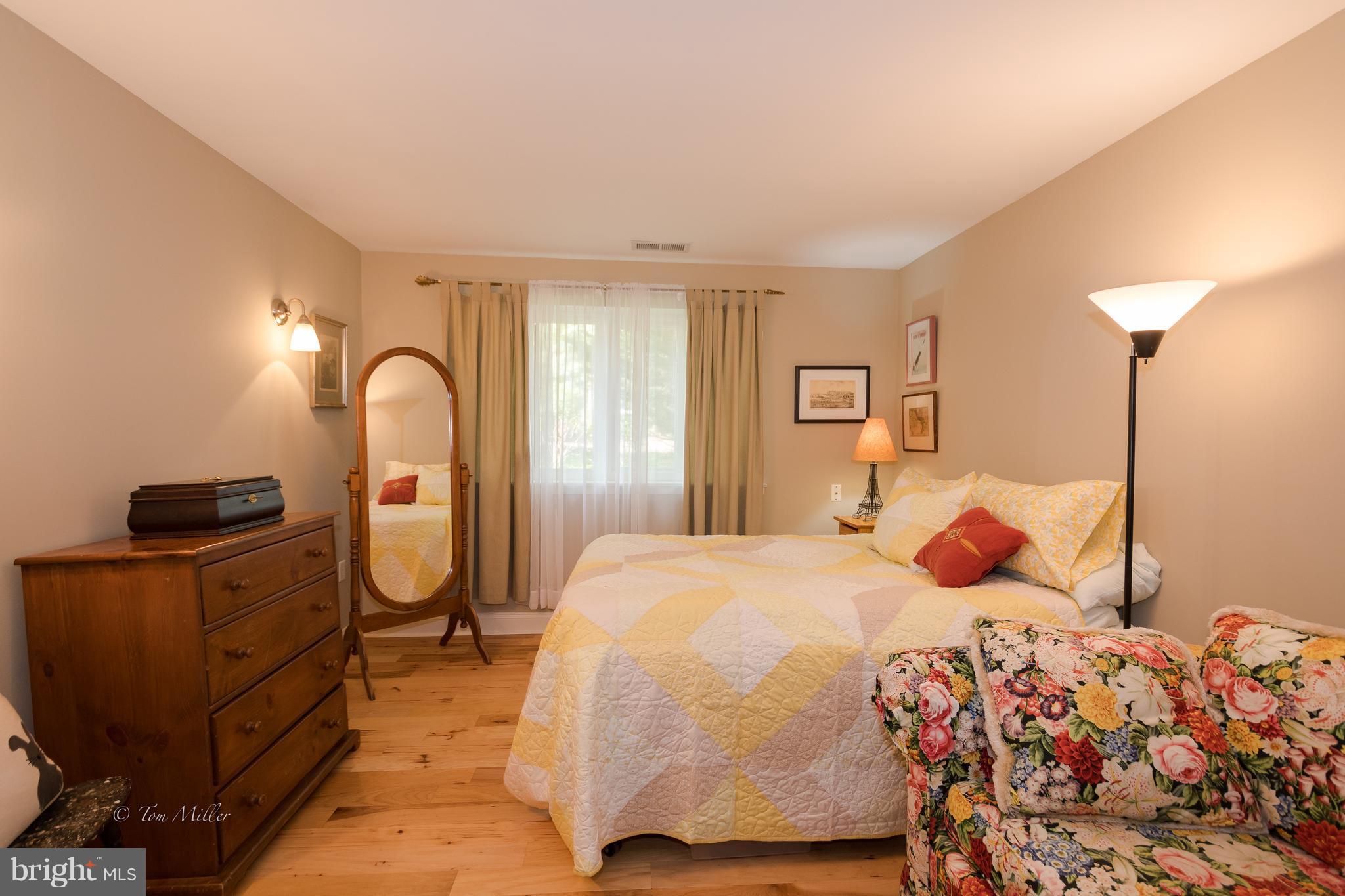 118 Cross Keys Road, Unit R118A Baltimore, MD 21210 - Photo 12 of 20 a bedroom with a bed and dresser with mirror