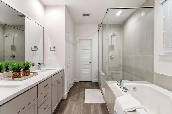 a bathroom with a tub sink shower and mirror
