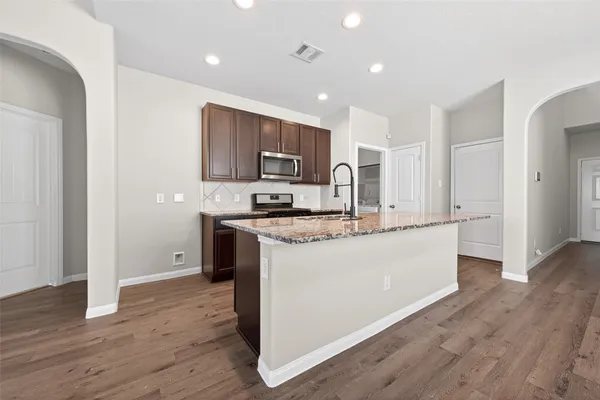 a kitchen with stainless steel appliances granite countertop a sink stove and refrigerator