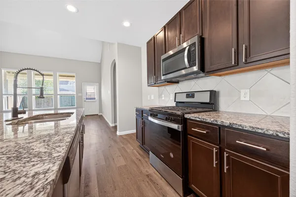 a view of a hallway with wooden floor and a ceiling fan