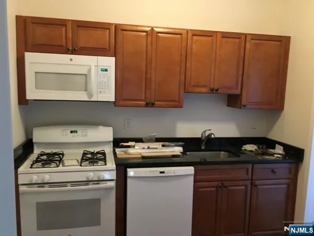 a kitchen with granite countertop a stove and a cabinets