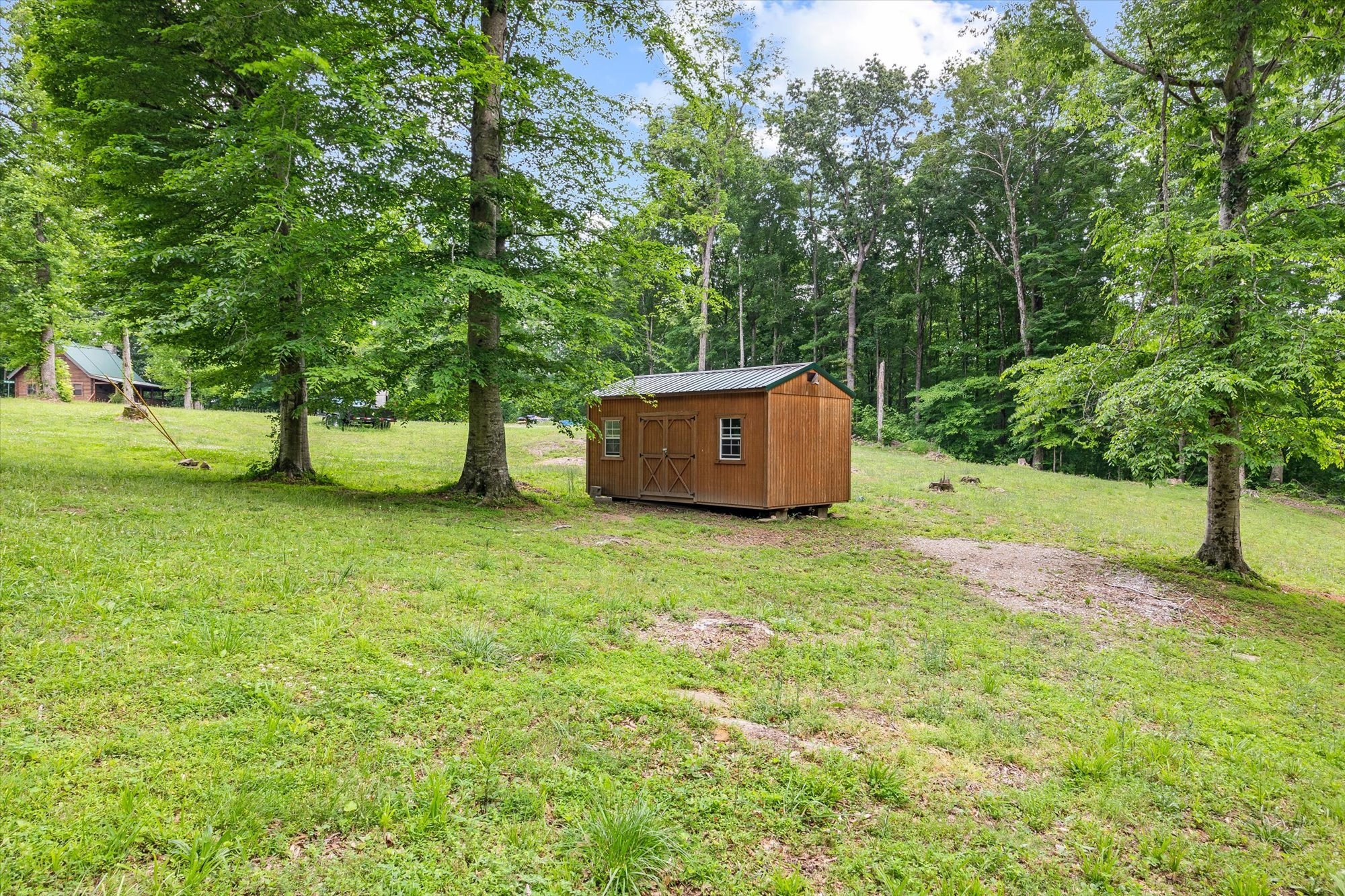 1103 Boles Beaty Road Alpine, TN 38543 - Photo 17 of 24 a backyard of a house with trees and grass