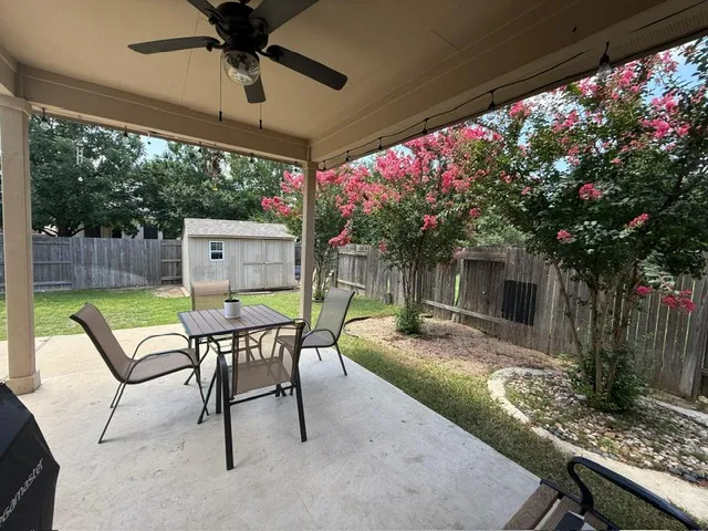 a view of a patio with a table chairs and a small yard