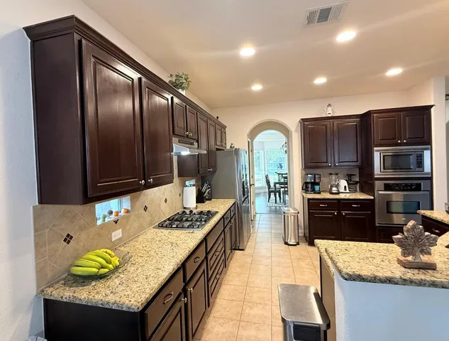 a kitchen with granite countertop stainless steel appliances and wooden cabinets