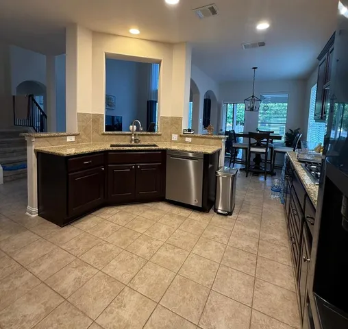 a kitchen with a sink counter top space and stainless steel appliances