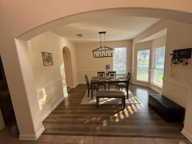 a view of a dining room with furniture wooden floor and chandelier