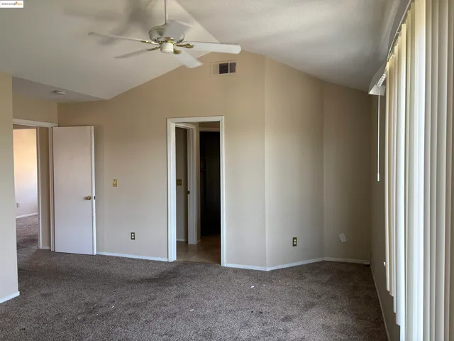 a view of a big room with closet and a chandelier fan