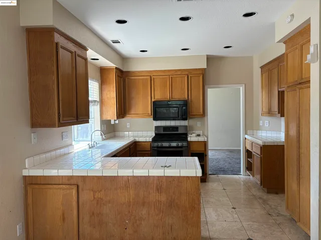 a kitchen with stainless steel appliances granite countertop a sink a stove and a refrigerator