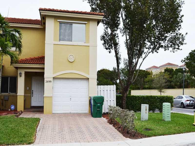 2899 Southwest 129th Terrace, Unit 2899 Miramar, FL 33027 - Photo 1 of 16 a front view of a house with garden