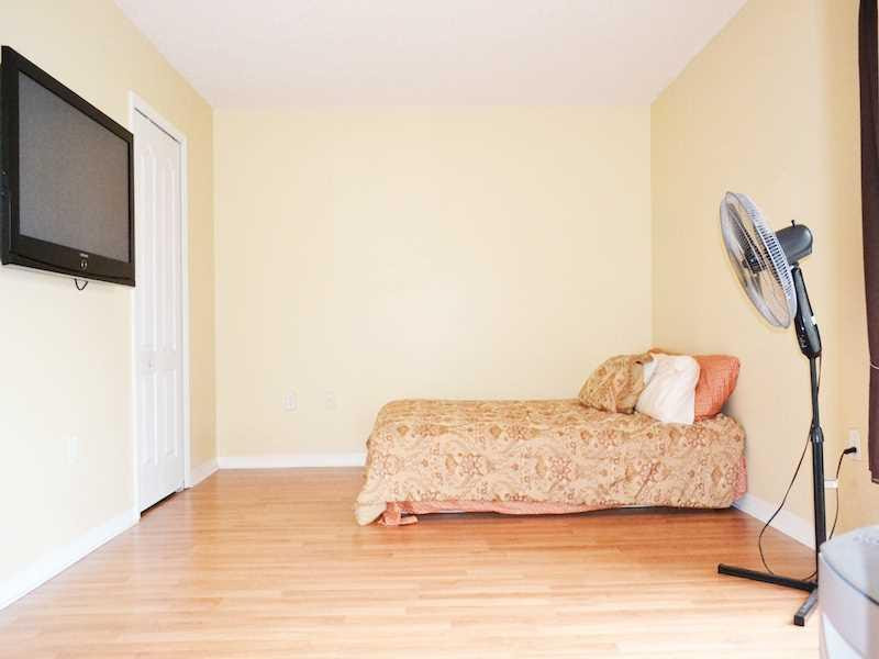 2899 Southwest 129th Terrace, Unit 2899 Miramar, FL 33027 - Photo 12 of 16 a bedroom with a bed and a flat screen tv