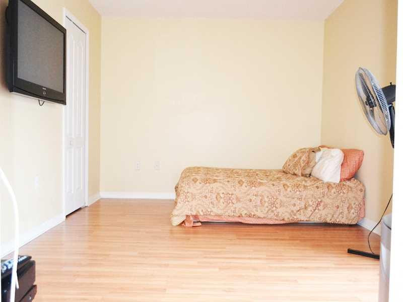2899 Southwest 129th Terrace, Unit 2899 Miramar, FL 33027 - Photo 13 of 16 a living room with a bed furniture and a flat screen tv