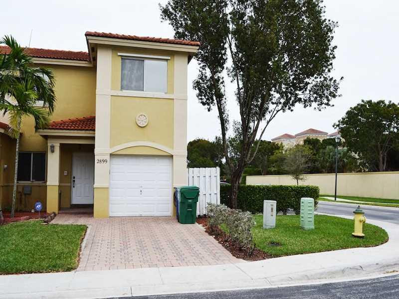 2899 Southwest 129th Terrace, Unit 2899 Miramar, FL 33027 - Photo 2 of 16 a front view of a house with garden