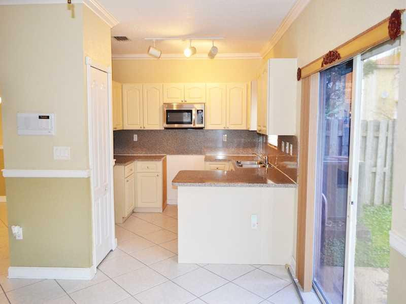 2899 Southwest 129th Terrace, Unit 2899 Miramar, FL 33027 - Photo 5 of 16 a kitchen with a refrigerator and a sink