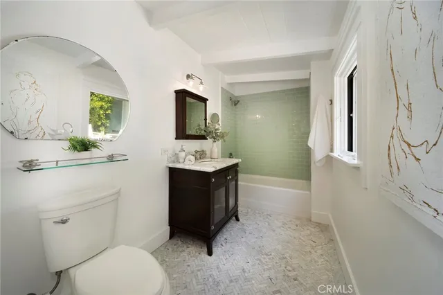 a bathroom with a sink toilet vanity and mirror