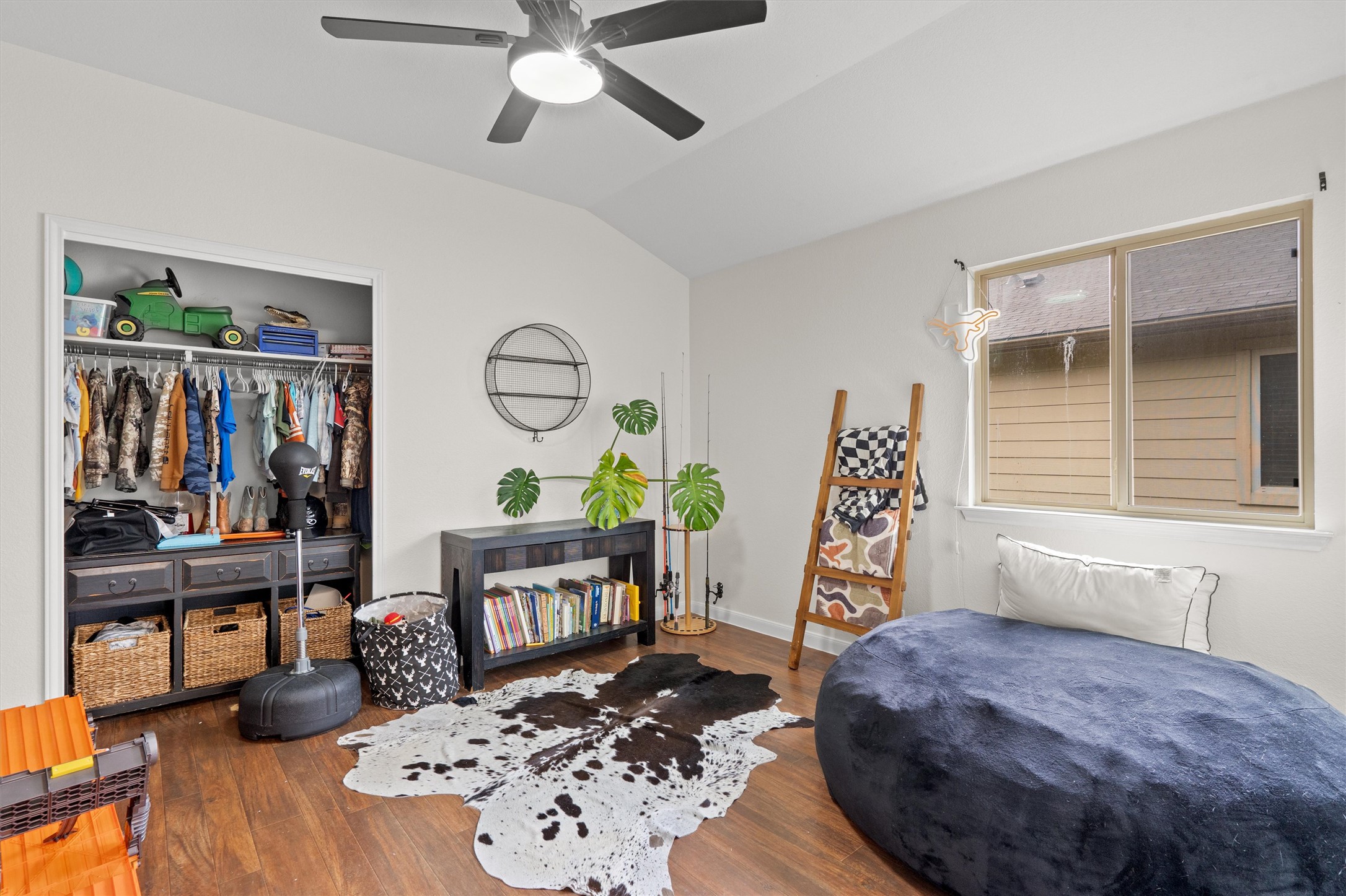 606 Old Peak Road Georgetown, TX 78626 - Photo 14 of 23 Vaulted ceiling room featuring wood-finish flooring, a ceiling fan with integrated lighting, a built-in closet system with shelving and hanging rods, and a window with horizontal blinds