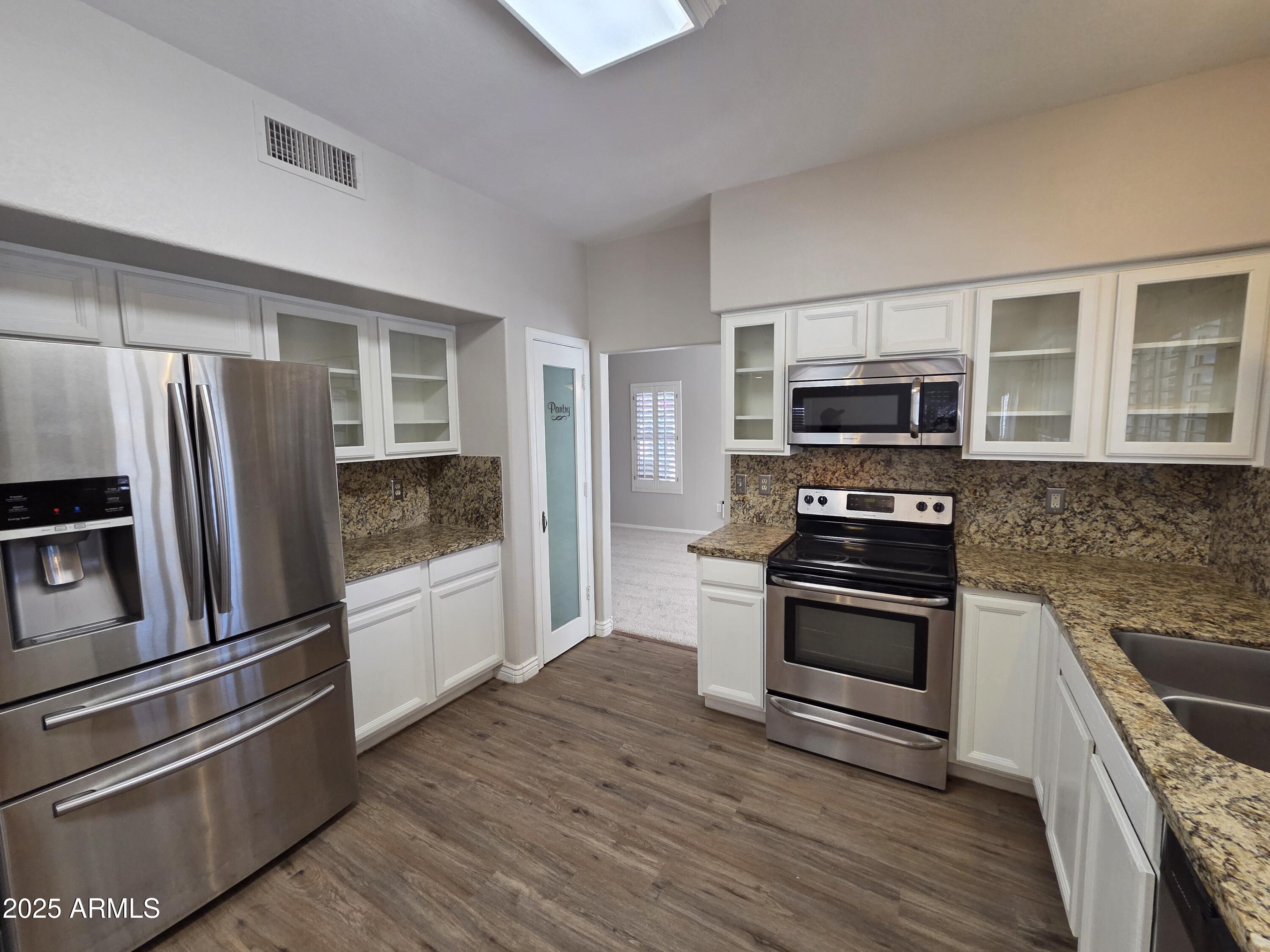30651 North 44th Street Cave Creek, AZ 85331 - Photo 3 of 18 a kitchen with granite countertop a refrigerator stove and microwave