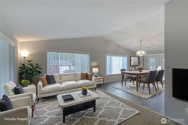 a living room with furniture a dining table and a potted plant