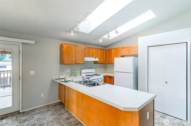 a kitchen with stainless steel appliances a refrigerator sink and white cabinets