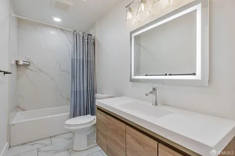 a bathroom with a sink a toilet and shower