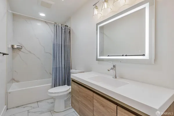 a bathroom with a sink a toilet and shower