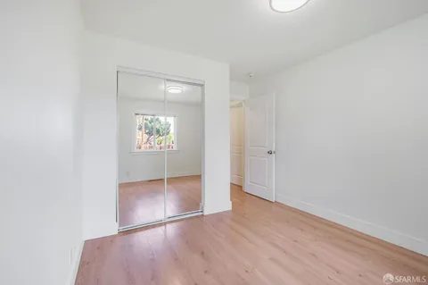 an empty room with wooden floor and mirror