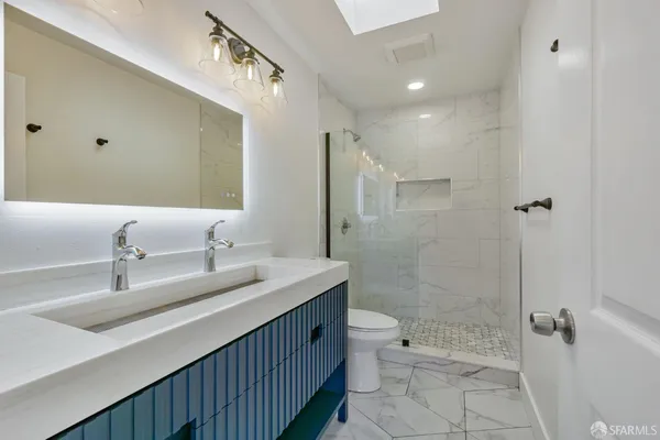 a bathroom with a double vanity sink toilet and shower